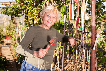 Naklejka na ściany i meble Woman holding garden tools