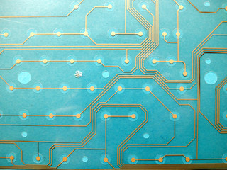 Circuit board made of plastic with circuit traces on blue background. The concept of technology, computing, electronics.