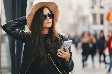 Obraz premium stylish girl in brown hat using phone in istanbul turkey