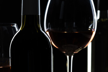  wine bottle and wine glass in a black background