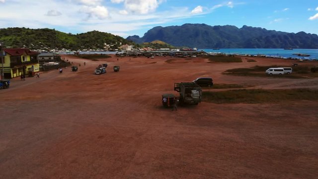 Aerial Pan Over Dusty Dirt Road at Coron Island Market.