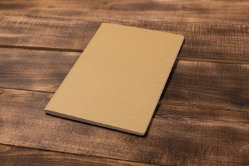 A blank notebook page and pen on wood office table. Top view with copy space.