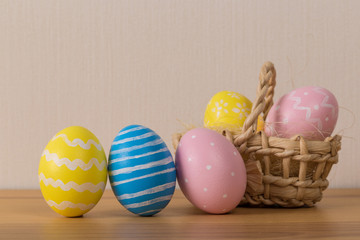 Easter eggs in the basket of wooden background.