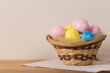 Easter eggs in the basket of wooden background.