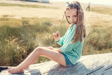 Pretty little girl relaxing on the beach near sea