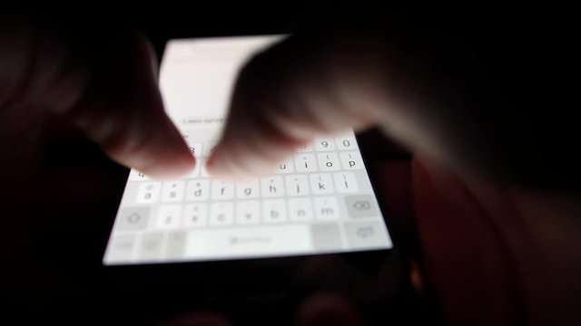 Male Hand Typing on Smartphone Touchscreen Keyboard in the Dark