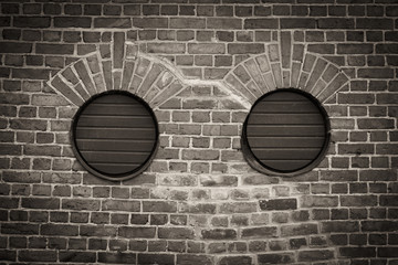 Two round holes in brick wall