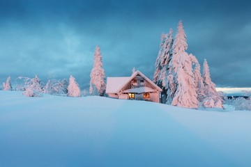 Beautiful snowy winter landscape with cottage cabin village in christmas vacation time near ski...
