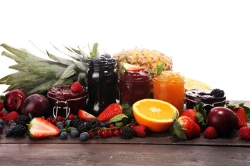 assortment of jams, seasonal berries, plums, mint and fruits in glass jar