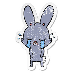 Fototapeta na wymiar distressed sticker of a cute cartoon rabbit crying