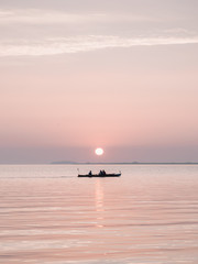 Fototapeta premium Small boat sunrise on the sea