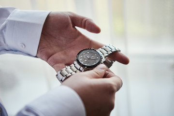 businessman checking time on his wrist watch, man putting clock on hand,groom getting ready in the morning before wedding ceremony. Men Fashion