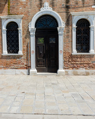 Fototapeta na wymiar Italy, Venice, a stone building that has a bench in front of a brick wall