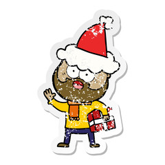 distressed sticker cartoon of a bearded man with present wearing santa hat