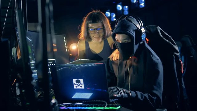 Two cheerful hackers during work in their hideout