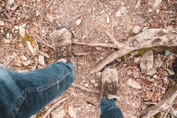 dirty hiking boots with jeans on trail