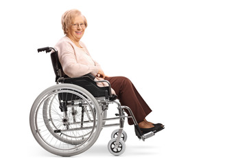 Obraz na płótnie Canvas Senior woman in a wheelchair smiling at the camera