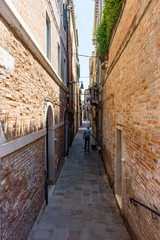Fototapeta na wymiar Italy, Venice, a stone building that has a narrow street