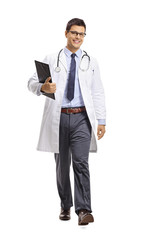 Young male doctor holding a clipboard and walking towards the camera