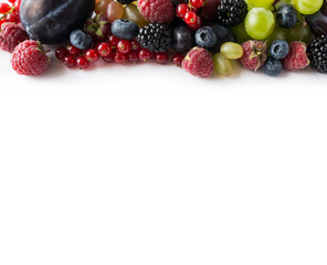 Ripe red currants, grapes, blackberries, blueberries, raspberries and plums on white background. Top view.  Mix berries and fruits. Background berries and fruits. Various fresh summer fruits.