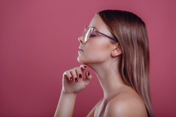 glamor woman in glasses on a pink background