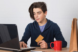 young man with credit card and laptop buying online