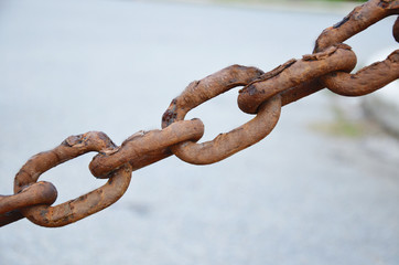 Rusty metal chains on the background of stones
