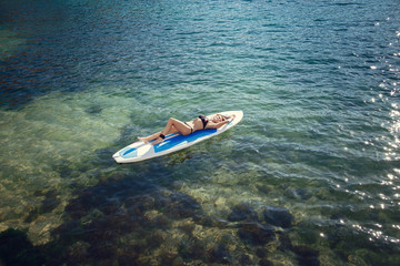 Young Attractive Woman on SUP in the Blue Waters