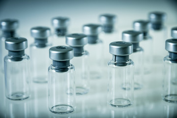 Vaccine glass bottles on grey background