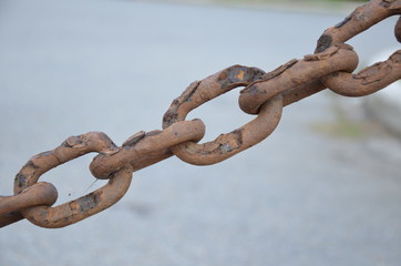 Rusty metal chains on the background of stones