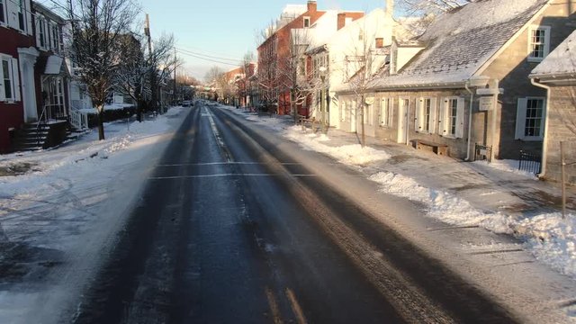 Empty streets in early morning Lititz, fresh snow on roads, push forward over road, no people.