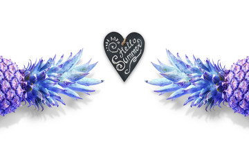 Creative concept with pineapple and heart with the inscription "Hello summer." The top of the pineapple is colored gradient. Flat lay, top view, copy space. Minimum summer concept.