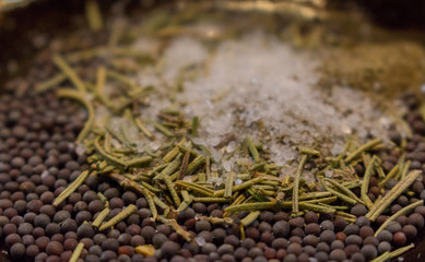 Dried rosemary with black mustard seeds, salt and black pepper powder closeup. Spices background. Organic healthy food. Cuisine and cooking concept. Herbs in  kitchen. Aroma herbs and spices on plate.
