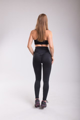 Back view of sporty woman. Strong woman. Beautiful young sporty muscular fitness model
