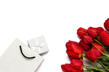 Beautiful red tulips, packing package and gift box on a white background. Top View.