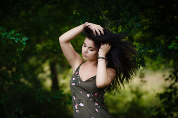 Naklejka premium young girl standing by the leaves