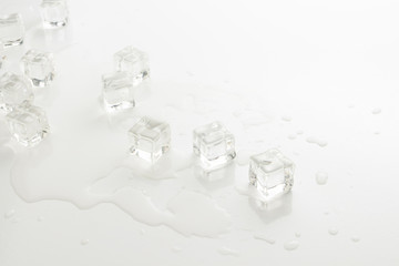 Cubes of ice and spilled water on a light background