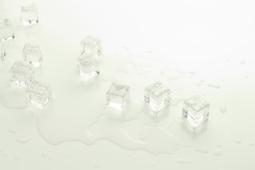 Cubes of ice and spilled water on a light background
