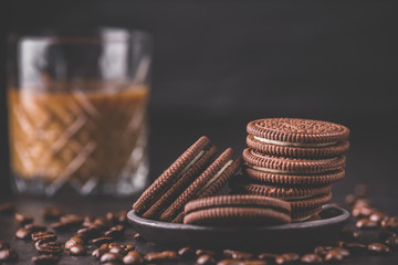 Chocolate chips cookies on black background. Latte coffee on background. Matte toned