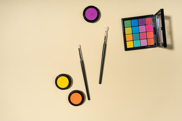 Set of brushes and eyeshadows on a yellow background