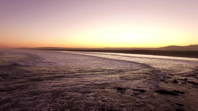 Sunset drone shot over sea waves near Paternoster in South Africa.