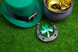 Happy St Patricks Day leprechaun hat with gold coins and lucky charms grass. Top view