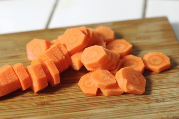 Sliced carrots for cooking dinner or supper on a wooden cutting board in the kitchen. Vegeterian diet nutrition