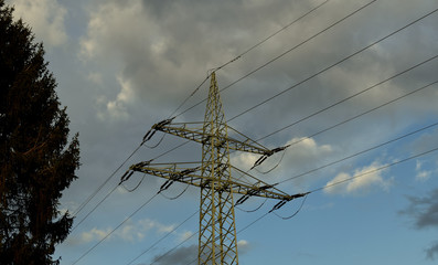 Power line support.Against the blue sky and dark clouds.