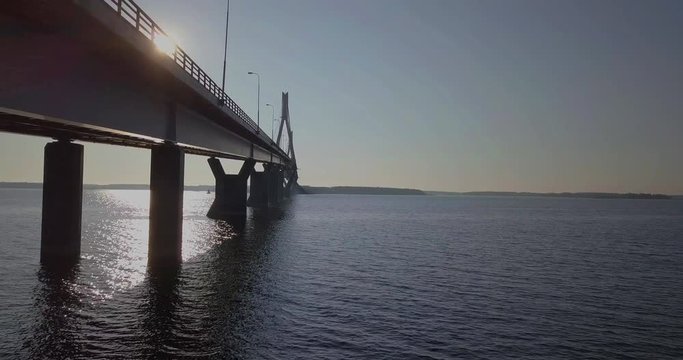 Aerial, rising, drone shot, of Raippaluodon silta and a car driving over the longest bridge in Finland, in Kvarken archipelago, on a sunny, summer morning, in Vaasa, Pohjanmaa
