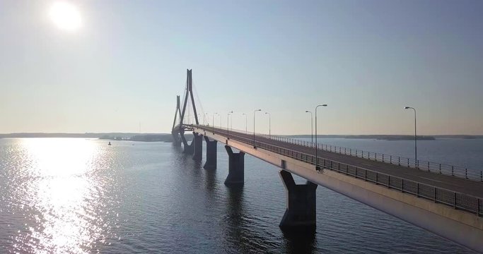 Aerial, rising, drone shot, of a car driving over the Raippaluodon silta, the longest bridge in Finland, in Kvarken archipelago, on a sunny, summer morning, in Vaasa, Pohjanmaa