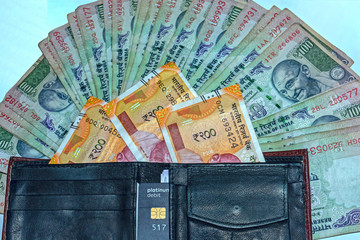 Close up view of wallet with 200 rupees and old 100 rupees Indian banknotes on background.