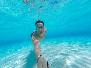 Hispanic men swimming underwater