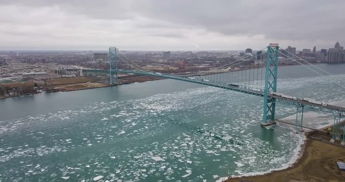 Ice floats below the Ambassador Bridge as cars and transport trucks cross into Michigan.