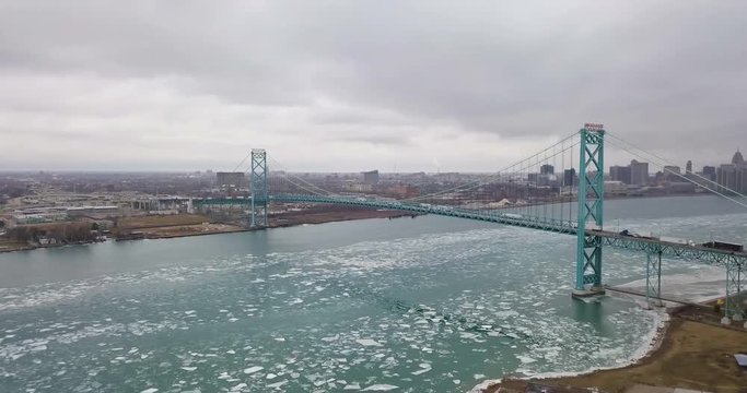 Cars and transport trucks crossing from Windsor to Detroit via the Ambassador Bridge in winter.